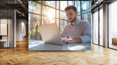 High-resolution brightly lit photorealistic candid photograph of a confident young marketer in casual attire, focused on his laptop in a sunlit office. The photograph is styled like a high-end Wall mural