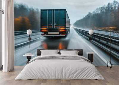 Rear view of a transport truck accelerating on a wet road, with motion blur in the background adding drama, representing fast and reliable freight services Wall mural