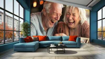 Senior couple laughing together while looking at old photos, their happiness in retirement evident in their joyful expressions Wall mural