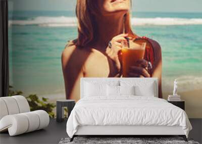 Beautiful woman drinking cocktail on the tropical sandy beach. Wall mural