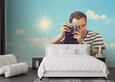 Young hipster man photographing with vintage camera. Wall mural