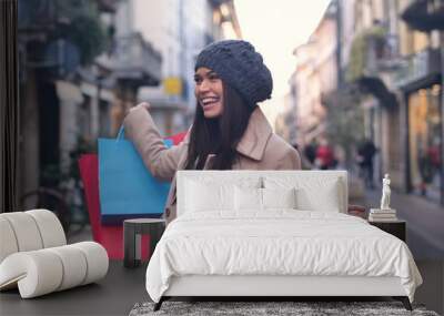 A beautiful smiling young girl, while she is having a shopping day. Concept of: shopping, entertainment, friendship, love and leisure. Wall mural