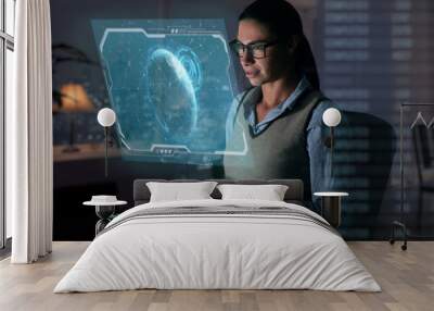 Close up of a beautiful girl with glasses while she is working with a futuristic computer with holograms. Concept: Future, technology, work Wall mural