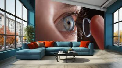 Close-up of a man putting contact lenses on blue eye. Concept of: healtcare, optic, hydration of the eye. Wall mural