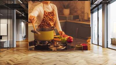 Indian Girl Preparing Food: Young Woman in Apron Preparing Delicious Home-Cooked Traditional Meal in Kitchen. Close Up on Pot While She is Steering. Celebrating Traditional Culture Wall mural