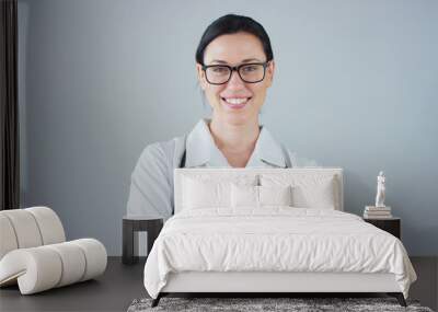 Portrait of a female doctor with white coat and stethoscope smiling looking into camera on white background. Concept: doctor, health care, love of medicine. Wall mural