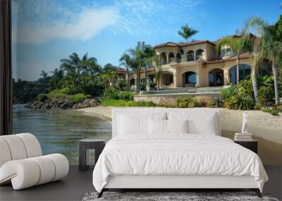 A stunning luxury mansion exterior with private beach, surrounded by lush palm trees and vibrant greenery. serene water reflects beautiful architecture, creating tranquil atmosphere Wall mural