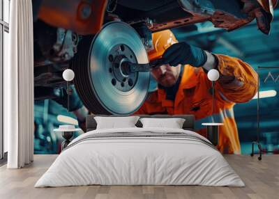 Mechanic performing brake inspection on vehicle, wearing an orange safety jacket and helmet, focused on task at hand. workshop is well lit, showcasing intricate details of brake system Wall mural