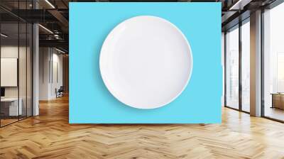 empty white ceramic plate isolated on blue background. Wall mural