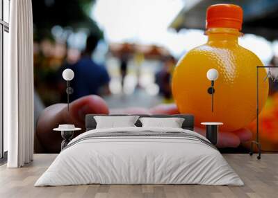 Fresh Orange juice bottle on the hand - beverage drink scene for take a way  Wall mural