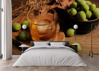 Homemade plum wine or UMESHU and green plums on wooden plate. Wall mural