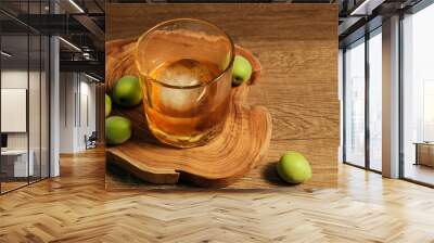 Homemade plum wine or UMESHU and green plums on wooden plate. Wall mural