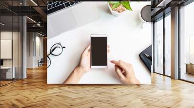 Hand holding empty screen Smart phone on business desk office with copy space, Top view Wall mural