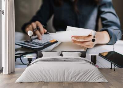 Stressed young woman checking bills, taxes, bank account balance and calculating expenses in the living room at home Wall mural