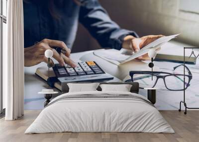 Stressed young woman checking bills, taxes, bank account balance and calculating expenses in the living room at home Wall mural