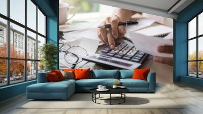 Stressed young woman checking bills, taxes, bank account balance and calculating expenses in the living room at home Wall mural