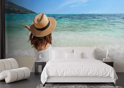 Young couple traveler holding hands relaxing and enjoying at beautiful tropical white sand beach with wave foam and transparent sea, Summer vacation and Travel concept Wall mural