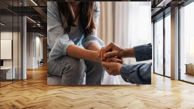 Young man comforting and supporting a sad woman who is in serious trouble at home, Consolation and encouragement concept Wall mural