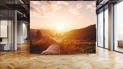 Young man hand reaching for the mountains during sunset and beautiful landscape Wall mural