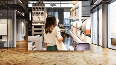 Young woman choosing furniture in a modern home furnishings store Wall mural