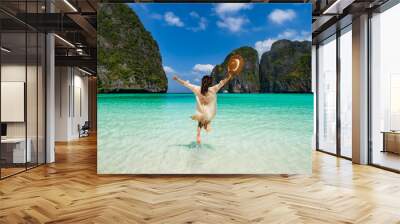 Young woman traveler relaxing and enjoying at beautiful tropical white sand beach at Maya bay in Krabi, Thailand, Summer vacation and Travel concept Wall mural