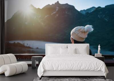 Young woman traveler with a cup of coffee looking beautiful mountains view in the morning Wall mural