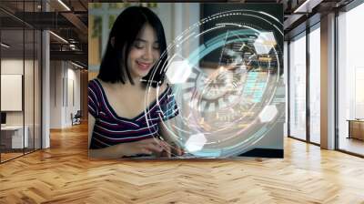 Young Asian teenage girl typing on a futuristic concept wireless keyboard using a holographic head up display computer terminal to surf the net and search for online informations and communication Wall mural