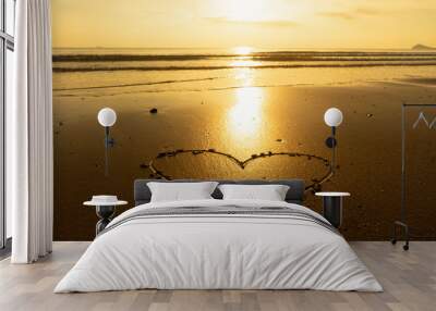 The heart in the sand while the sun is golden. Wall mural