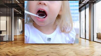 closeup female hands, dentist, doctor examines oral cavity of small patient, blonde girl 2 years old, molars grow, kid with open mouth, close up of child’s mouth, white teeth Wall mural