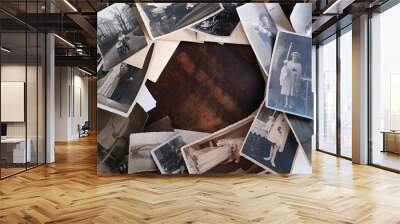 on an old wooden table there are old photographs of 1950-1960, , concept of family tree, genealogy, childhood memories, connection with ancestors Wall mural