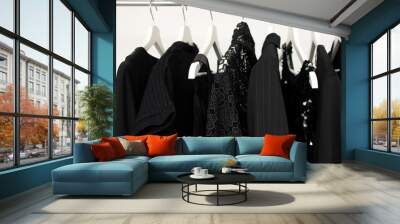 set of women's clothing in black in different colors on hangers, a concept for fashion, mourning and shopping Wall mural