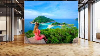 Landscape of beautiful tropical islands with incredible view of white sand beach and young female traveler enjoying scenery Wall mural