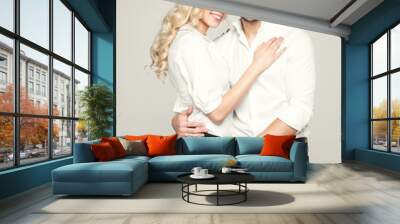 Fashionable couple in white shirt, posing on grey background Wall mural