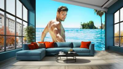 Portrait of handsome man in swimming pool Wall mural