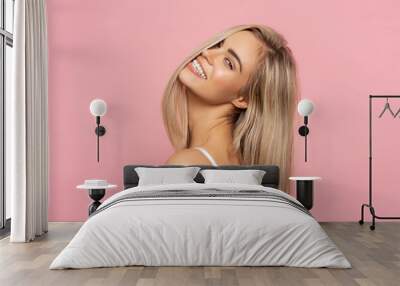 Portrait of happy blonde woman with long straight hair isolated on pastel background Wall mural