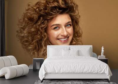 Portrait of smiling young woman with white teeth and curly hair. Beauty portrait of female face with healthy natural skin.  Wall mural