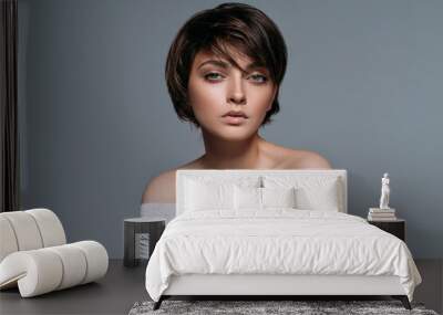 Studio shoot of young sensual brunette woman with short hair isolated on grey background Wall mural