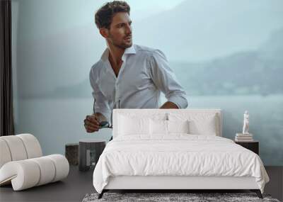 Stylish man in white classic shirt, looking at the mountains view Wall mural