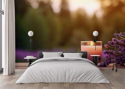 a burning candle and lavender flowers against the background of a garden. banner with copy space. Wall mural