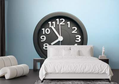 Black Alarm clock isolated on blue background, showtime 07.54 am or pm, Copy space for your text, Time concept. . Wall mural