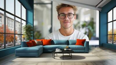 Confident Young Entrepreneur in Casual Wear Posing in Open-Plan Office with Clean Background Wall mural