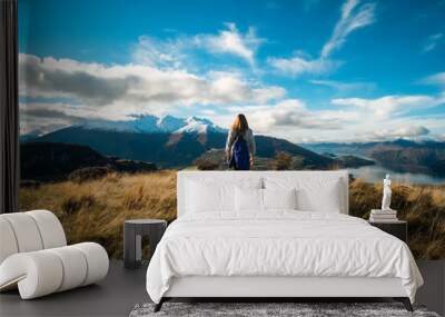 Wanaka. Roys Peak Track, South Island, New Zealand. A hiker hiking on the beautiful track with a landscape of the mountains and Lake. Wall mural