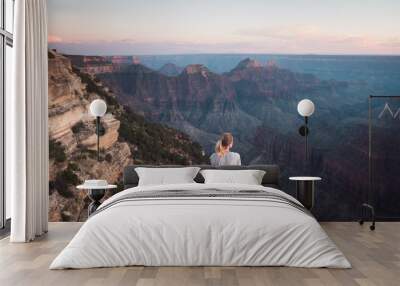 Grand Canyon, USA: Young attractive girl sits on the edge of the cliff, enjoys sunset Wall mural