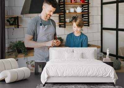 family dad young man and son teenage boy cook vegetable salad in kitchen and spend quality time together, father and son talking and cooking vegetarian food and doing chores, 8 march and mothers day Wall mural