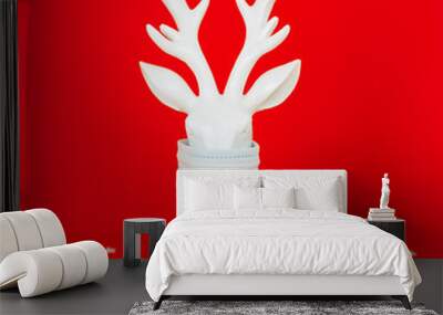 white deer in protective face mask on red background, minimal creative concept of Christmas and New Year Wall mural