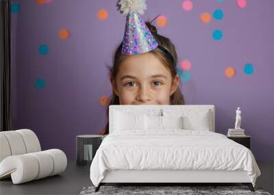 cheerful child with purple glitter party hat and colorful confetti background Wall mural