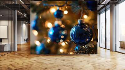 festive blue Christmas ornaments hanging on a tree with sparkling lights Wall mural