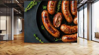 grilled sausages cut open on a black plate with herbs showing stuffing Wall mural