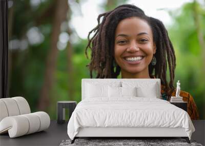 smiling young black woman with dreadlocks enjoying nature, wearing vibrant African print shirt Wall mural