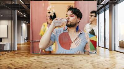 Brazilian Carnival. Person drinking water during carnival block on the street Wall mural